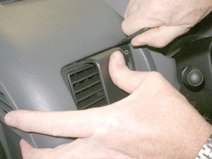 Händer tar bort en del av instrumentpanelen i en Fiat Scudo.