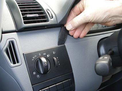 En hand justerar en nyckel eller kontroll i en bilinteriör.