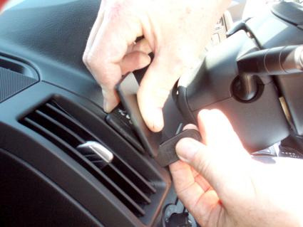 Två händer installerar en del i interiören av en Land Rover Freelander.