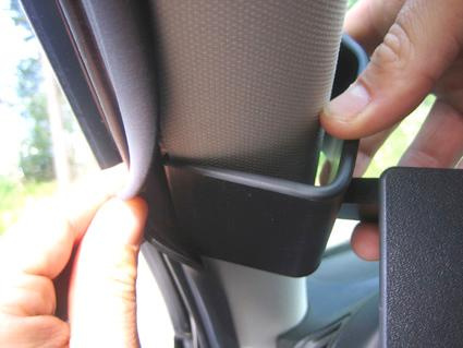 En hand justerar en del av inredningen vid A-stolpen i en Saab 9-3.