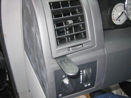 Kontrollpanel med ventilationsgaller och ratt för ljusinställning.