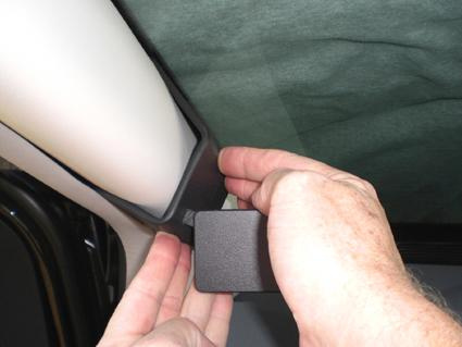 En hand installerar en del på taket av en Chrysler Voyager.