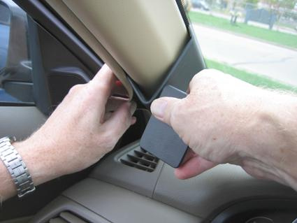 En hand som håller en del av inredningen i en Honda Accord 08-08.