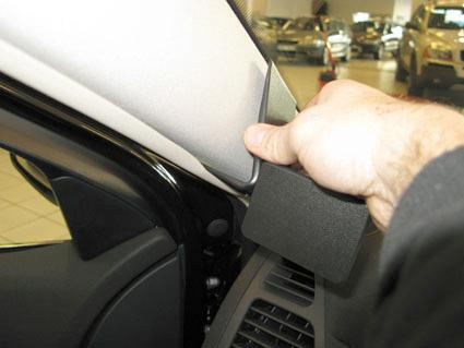 En hand justerar ett panelstycke i bilen Renault Laguna.