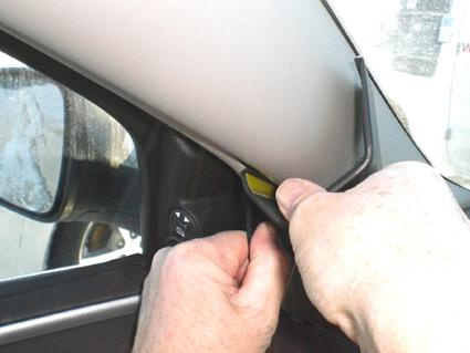 Händer som justerar en del av inredningen i en Chevrolet Malibu.