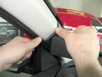 En hand justerar en del av bilen, troligtvis en insida av Nissan Qashqai.