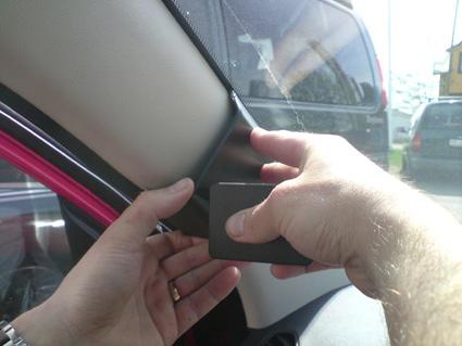 En hand som justerar en del på bilens inredning.