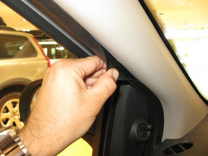En hand som håller i en förslutning på en bils dörrsida.