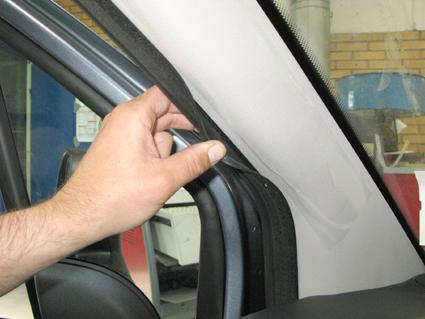 En hand justerar en gummilist vid fönsterramen i en Citroen Berlingo.