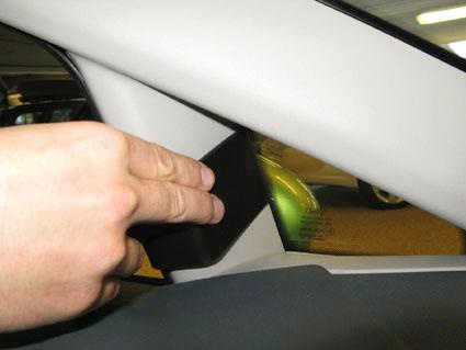 Hand som håller en del av interiören i en Ford Fiesta, troligtvis en panel.