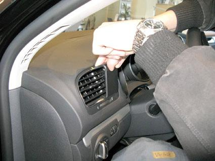 En hand justerar luftventilen i interiören på en Volkswagen Golf VI.