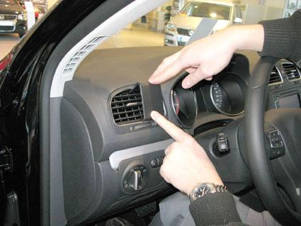 Visar en person som pekar på luftventilen inuti en Volkswagen Golf VI.