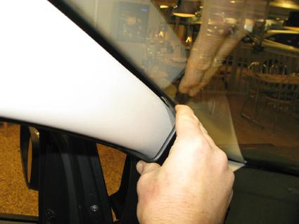 En hand justerar inredningen vid förarens sida i en Ford Ka.