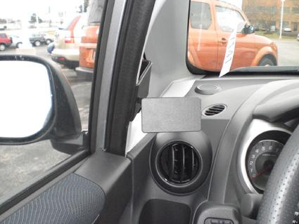 Bild av insidan av en bil med luftutlopp och en tom plats för tillbehör.