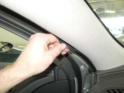 En hand justerar eller tar bort en del av inredningen i en Opel Insignia.