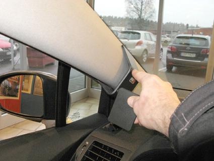 En hand pekar på en del av insidan av en Toyota Avensis.