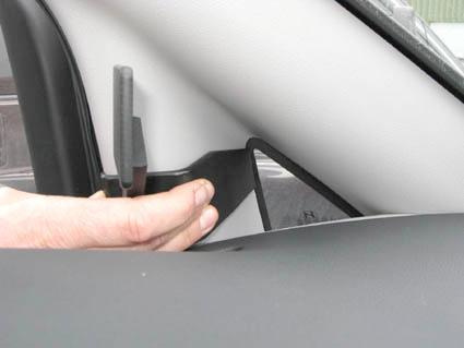 En hand håller i en del av inredningen i en Hyundai H1 09-15.