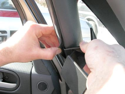 En person installerar en monteringsbygel i en bil.