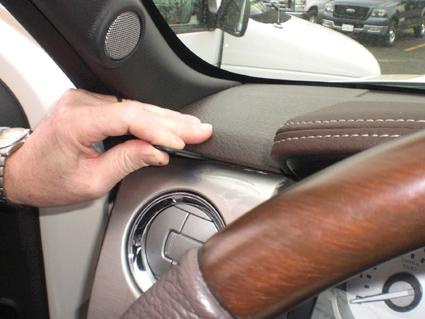 En hand som rör vid instrumentpanelen i en Ford F-Series 150 09-14.