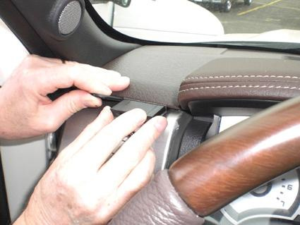 En person installerar en detalj på instrumentbrädan i en Ford F-Series 150.