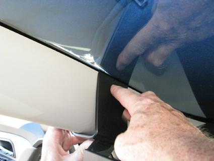 Hand som pekar på en del av bilen, troligen interiör från en Chevrolet Cruze 09-14.