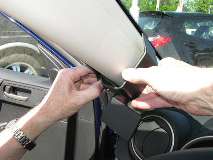 En person installerar en del av interiören i en Mazda 3.