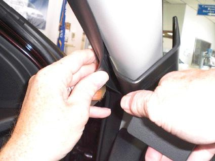 Bild av händer som installerar en del på Kia Cerato från 2010-2015, vänstersidan.