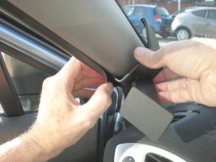 Händer som justerar eller installerar en del i en bilinteriör.