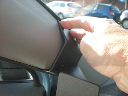 Hand som justerar en del av interiören i en Renault Scénic.