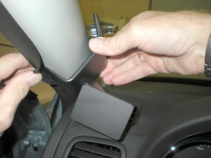 En hand håller i en del av interiören i en Skoda Yeti.