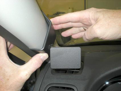 En hand installerar en del på instrumentpanelen i en Skoda Yeti.