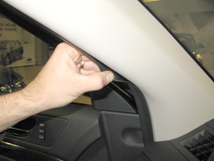 En hand justerar panelen vid förarens dörr.