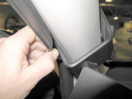En hand justerar en del av innerpanelen i en bil.