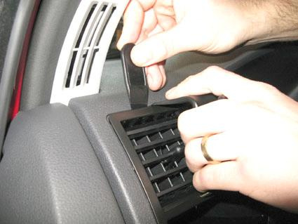 En hand justerar luftventilen i en Volkswagen Caravelle.