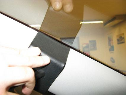 Ett närbild av en hand som trycker på en del av bilens inredning.