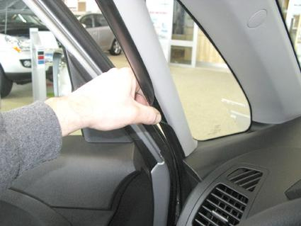 Hand som justerar en monteringsbygel i en bil.