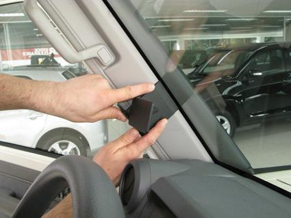 En hand installerar en komponent vid vindrutan på en Toyota LandCruiser 70.