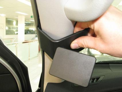 Hand som håller i en plastdel vid bilens A-stolpe.