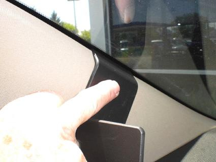 En hand pekar på en monteringsbygel för Suzuki Kizashi.