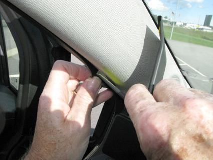 Händer som justerar ett inre bilkomponent i en Opel Meriva 11-15.