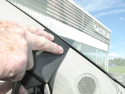 Bild visar en hand som håller i en del av inredningen nära vindrutan.