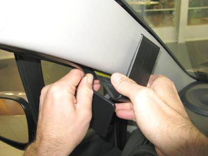 Två händer som justerar panelen på bilen Chevrolet Spark 11-14, vänster sida.