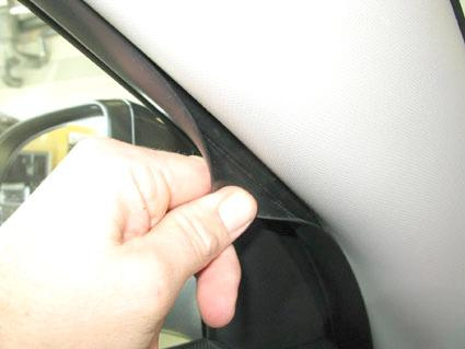 En hand som håller i en kant av inredningen i en bil.