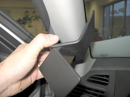 Del av inredning till Suzuki Swift, vänster sida, hand som håller en komponent.