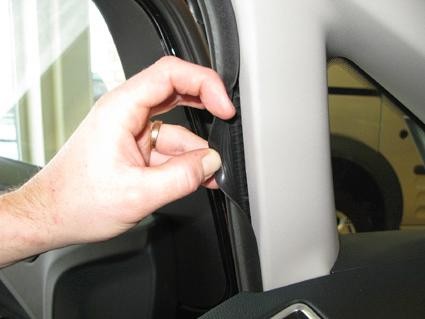 En hand som justerar en del av inredningen i en Ford C-Max.