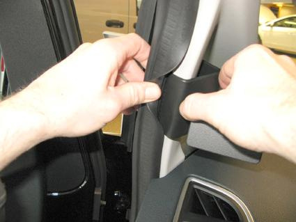 En person installerar eller justerar en del i en Ford C-Max/Grand C-Max.