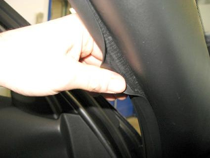 En hand som justerar en gummilist på en Nissan Juke 11-15.