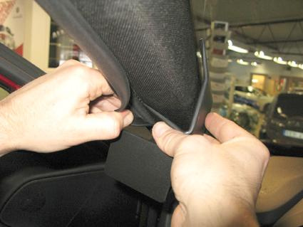 Två händer tar bort en bilinredningsdel.