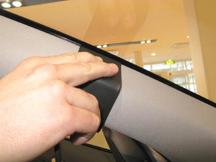 Bild visar en hand som håller i en del av innerpanelen i en Volvo S60.