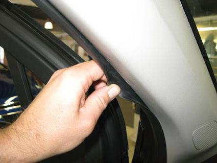 En hand som lyfter en del av inredningen i en Chevrolet Orlando.